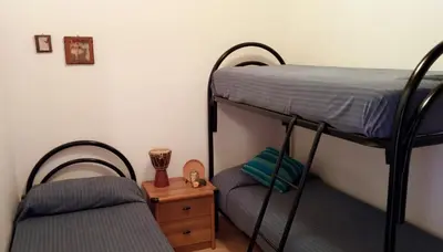 a bedroom with two bunk beds and a chair at Il Gelsomino Home Holiday in Alcamo