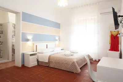 a white bedroom with a bed and a window at Country Villa San Vito Bay in San Vito lo Capo