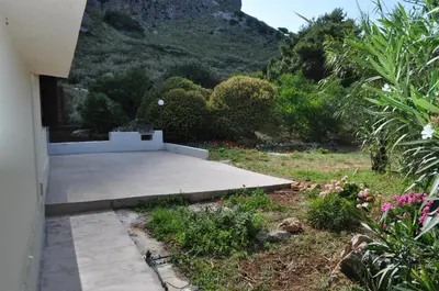 a concrete patio with a mountain in the background at Villetta Blusanvito in San Vito lo Capo