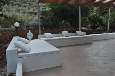 two white couches with pillows on a patio at Villetta Blusanvito in San Vito lo Capo