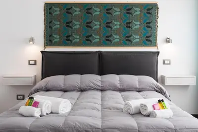 a bed with towels and a painting on the wall at Duca di Villena in Palermo