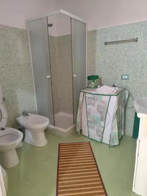 a bathroom with a shower and a toilet and a table at La Perla sul Golfo in Castellammare del Golfo