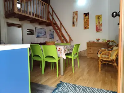 a kitchen with a table with green chairs at La Perla sul Golfo in Castellammare del Golfo