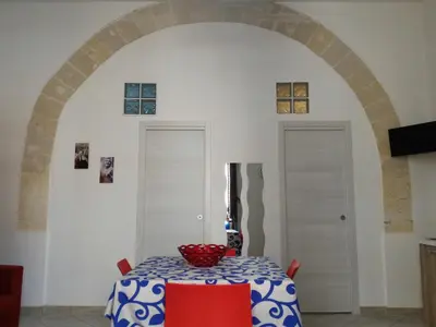 a dining room with a table and an archway at I due Archi in Castellammare del Golfo