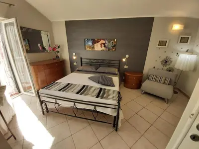 a bedroom with a bed and a chair in it at La perla della Conca d'Oro in Palermo