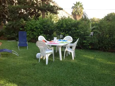 a white table and chairs in the grass at Villa Maria in Mondello