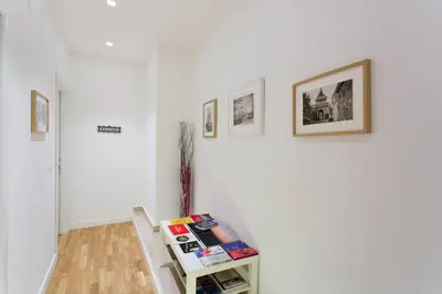 a room with white walls and a table with books at BB4U Apartments in Palermo