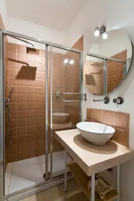 a bathroom with a sink and a shower with a mirror at BB4U Apartments in Palermo