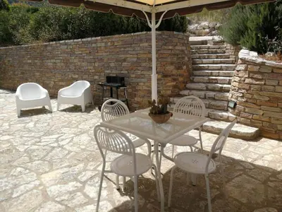 a table and chairs under an umbrella on a patio at Villa Rossana in Scopello