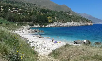 a group of people on a beach near the water at Two Steps From The Sea in Scopello