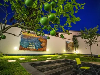 a garden with a painting on the wall and stairs at Tra Le Braccia di Morfeo in Terrasini
