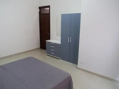 a bedroom with a bed and a dresser and a cabinet at Orange House a Castellammare del Golfo in Castellammare del Golfo