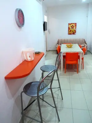a kitchen with a table and two chairs and a table and a dining room at Orange House a Castellammare del Golfo in Castellammare del Golfo