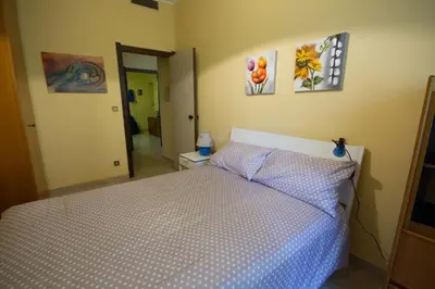 a bedroom with a bed and paintings on the wall at Lunetta in Palermo