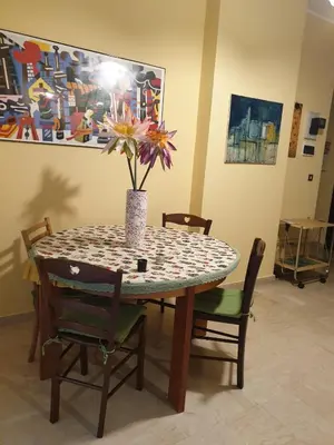 a dining room table with a vase with flowers on it at Lunetta in Palermo