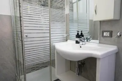 a bathroom with a white sink and a shower at A Mare Appartamenti in Castellammare del Golfo