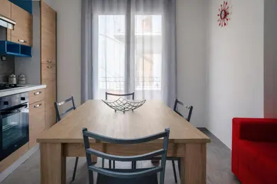 a kitchen with a wooden dining table and chairs at A Mare Appartamenti in Castellammare del Golfo