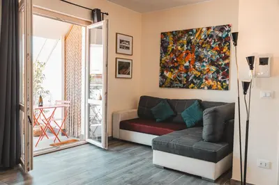 a living room with a couch and a painting on the wall at Attico 261 - Penthouse in Palermo
