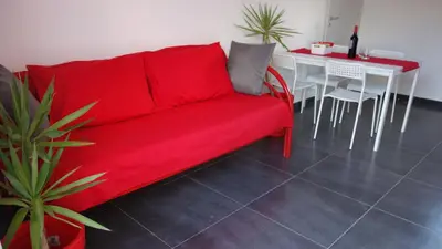 a red couch in a living room with a table at Casamatta in Trappeto