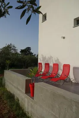 a group of red chairs sitting on a wall at Casamatta in Trappeto