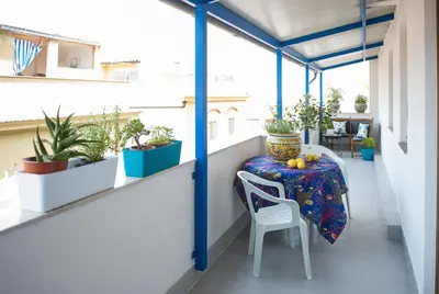 a balcony with a table and chairs and potted plants at Blue Suite in Castellammare del Golfo