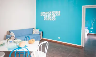a living room with a blue couch and a table at Blue Suite in Castellammare del Golfo