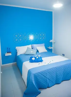 a blue bedroom with a bed with a stuffed animal on it at Blue Suite in Castellammare del Golfo