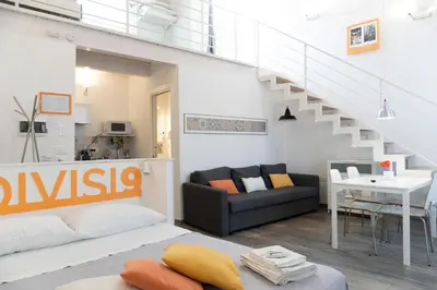 a living room with a staircase and a table and chairs at Divisi9 - apartment historic center Palermo in Palermo