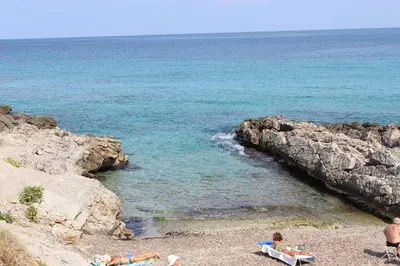 a group of people laying on a beach near the water at Mondello Addaura Home Holiday in Mondello