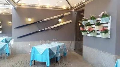 a dining room with a table and a tennis racket on the wall at Mondello Addaura Home Holiday in Mondello