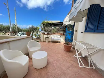 a patio with two white chairs and a table at Hellas Makari B&B in San Vito lo Capo