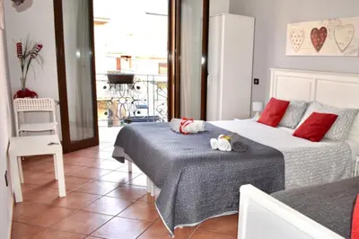 a bedroom with two beds and a balcony at Alma Nua in Terrasini
