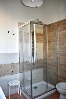 a bathroom with a shower with a toilet and a stool at Alma Nua in Terrasini