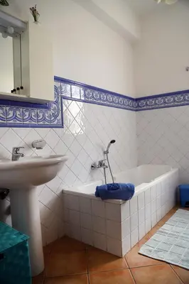 a bathroom with a white tub and a sink at Lucy's cottage in Cinisi