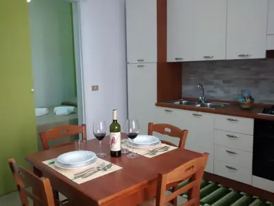 a kitchen with a wooden table with glasses of wine at Carpe Diem Apartments in Castellammare del Golfo