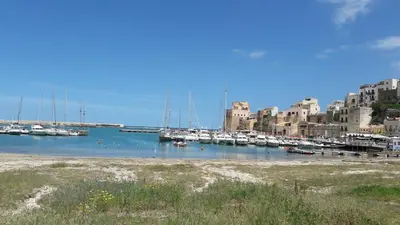 a marina with boats in the water next to buildings at N'amuri Residence in Castellammare del Golfo
