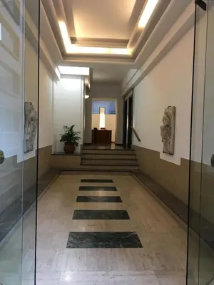 a bedroom with a white bed and a night stand at Caselita in Palermo