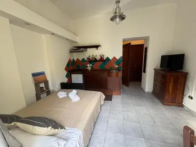 a bedroom with two beds and a dresser and a television at Apartment Co in Palermo
