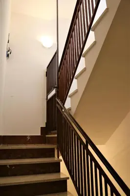 a staircase in a house with wooden railings at Casa Trio Apartments in Castellammare del Golfo