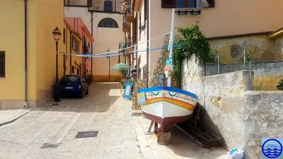 a boat sitting on the side of a building at Casa Trio Apartments in Castellammare del Golfo