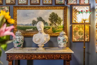a table with vases and a painting on a wall at Le Stanze al Genio di Darlon in Palermo