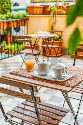 a wooden table with cups and saucers on it at Le Stanze al Genio di Darlon in Palermo
