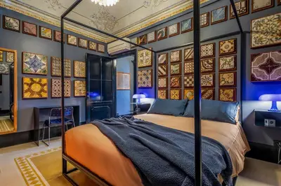 a bedroom with a bed and a wall with paintings at Le Stanze al Genio di Darlon in Palermo