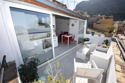 a balcony with a table and chairs on a building at Palazzo Taormina in Castellammare del Golfo
