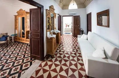 a living room with a white couch and a checkered floor at Palazzo Taormina in Castellammare del Golfo