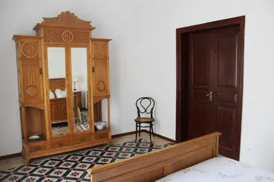 a bedroom with a dresser and a chair and a mirror at Palazzo Taormina in Castellammare del Golfo