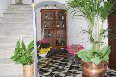 a room with potted plants on a checkered floor at Palazzo Taormina in Castellammare del Golfo