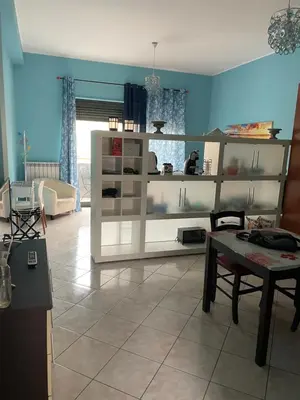 a living room with a white shelf and a table at Esmeralda Apartment in Palermo
