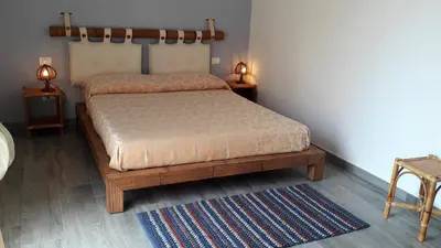 a bedroom with a bed and two tables and a rug at Il Bambu' in San Vito lo Capo