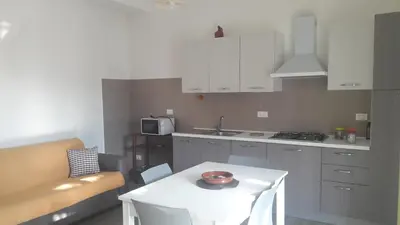a kitchen with white cabinets and a white table at Il Bambu' in San Vito lo Capo